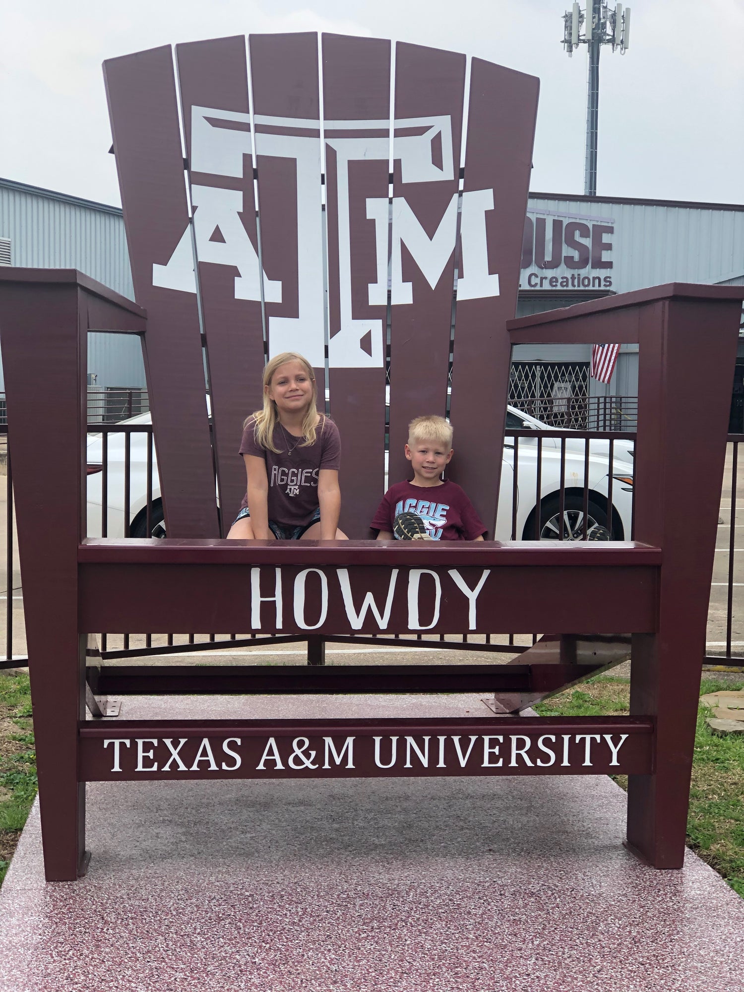 Two children sitting on oversized deck chair